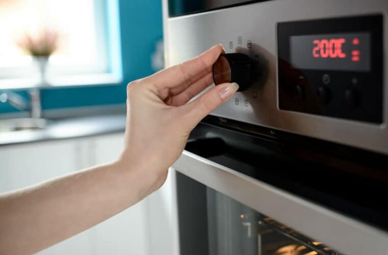 a hand adjusting the ovens timer