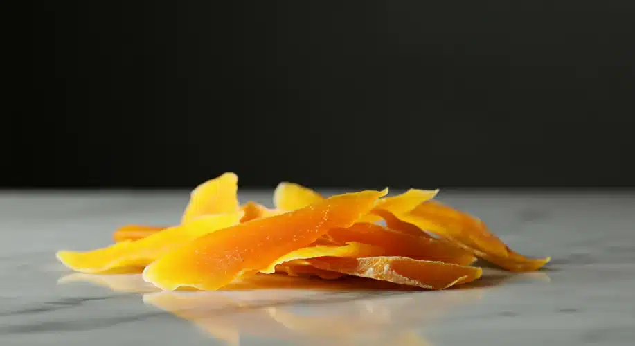 Dried mango candy snack on a marble countertop.