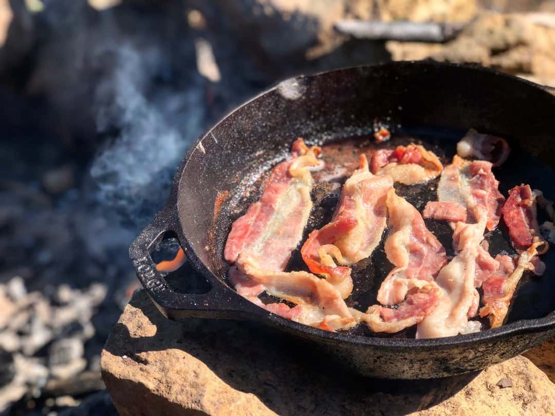 bacon being cooked in pan outdoors