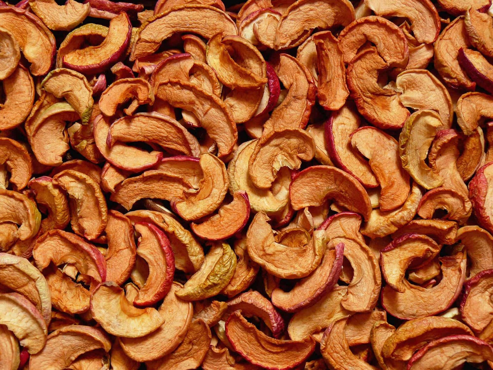 lots of dehydrated sliced red apple slices overlapping