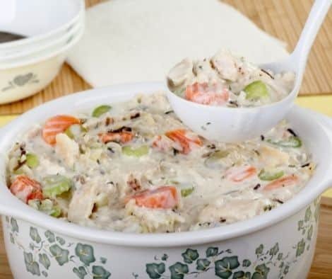 Laddle serving creamy chicken and rice with vegetables