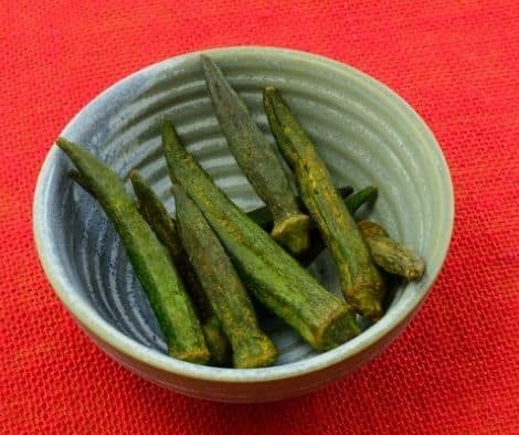 dehydrated okra chips in ceramic snack bowl on red tablecloth