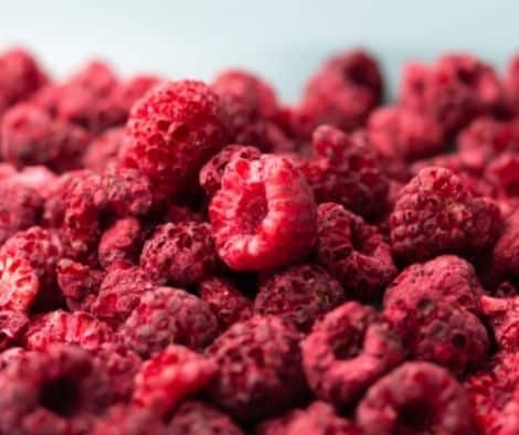 Heap of dried raspberries close-up. Dehydrated food background