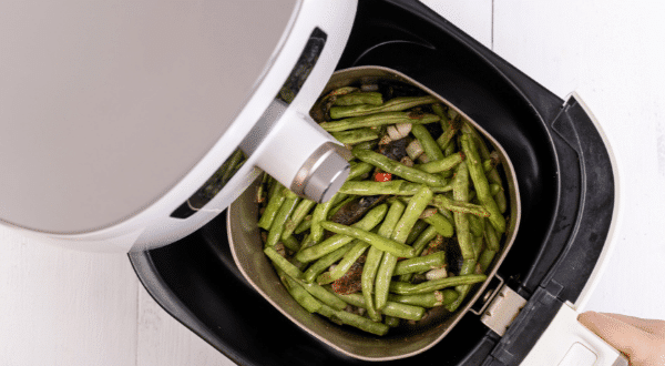open air fryer with green vegetable and food inside tray