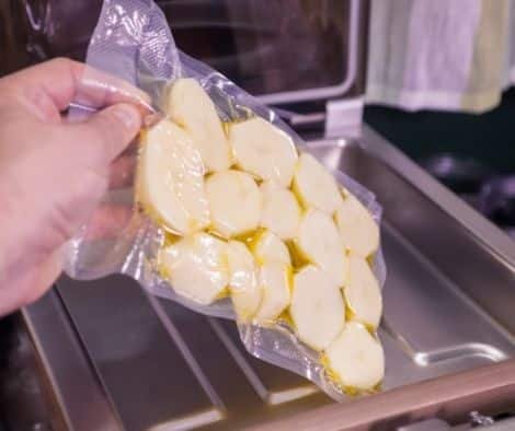 Person using vacuum seal machine for food packing.