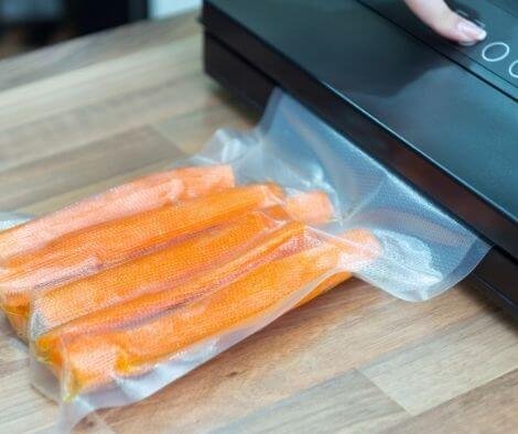 Sous-vide. Using vacuum seal machine for packing carrots.