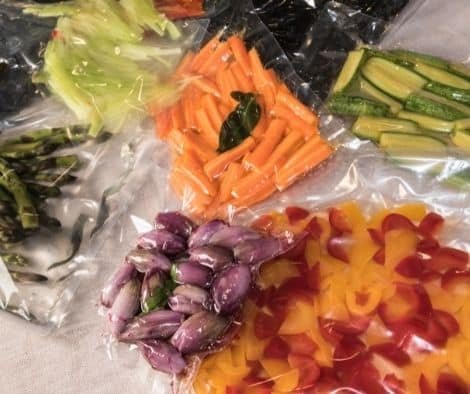 vacuum sealed bags for sous vide cooking with peppers and courgettes and shallots, fresh carrots and asparagus
