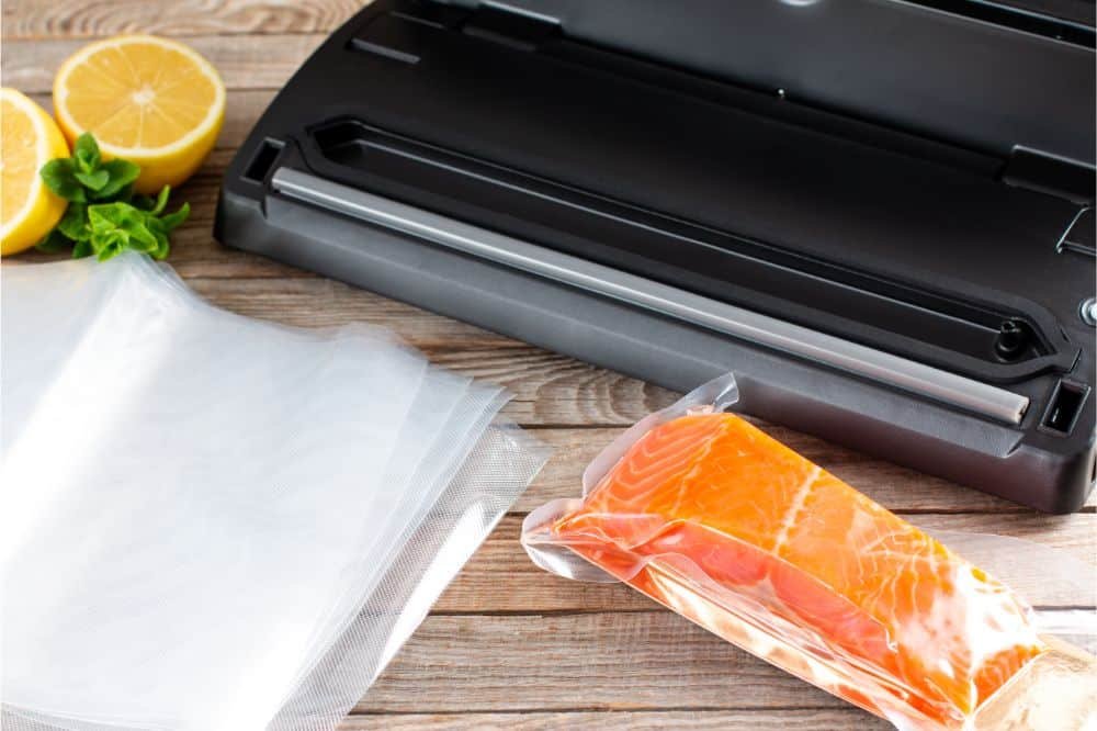 vacuum sealer machine on wooden table with vacuum salmon packed