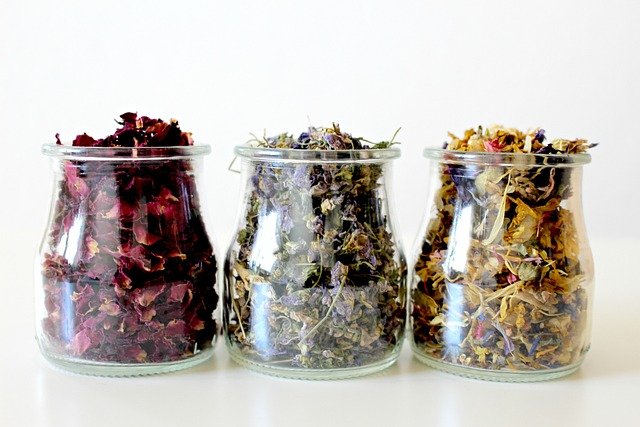 dried flowers, red roses, green flowers in three glass jars.