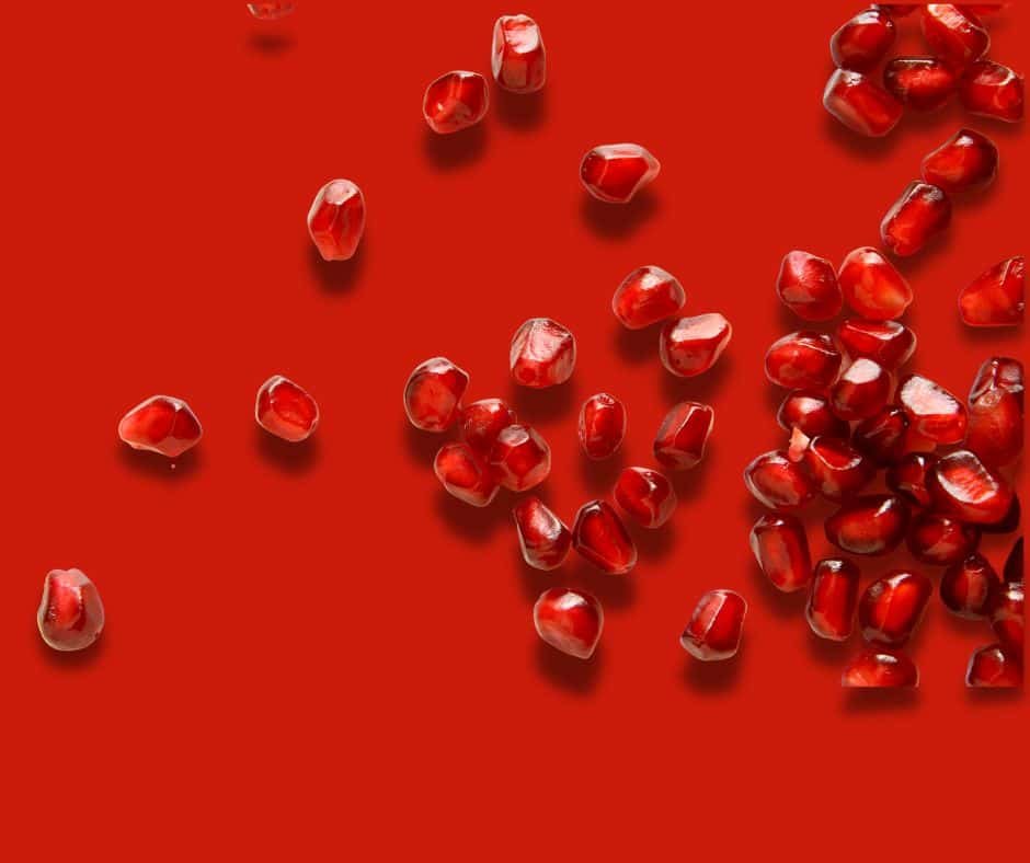 pomegranate seeds on red background