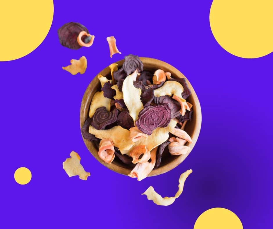 dehydrated vegetable chips in bowl on purple background with yellow circles