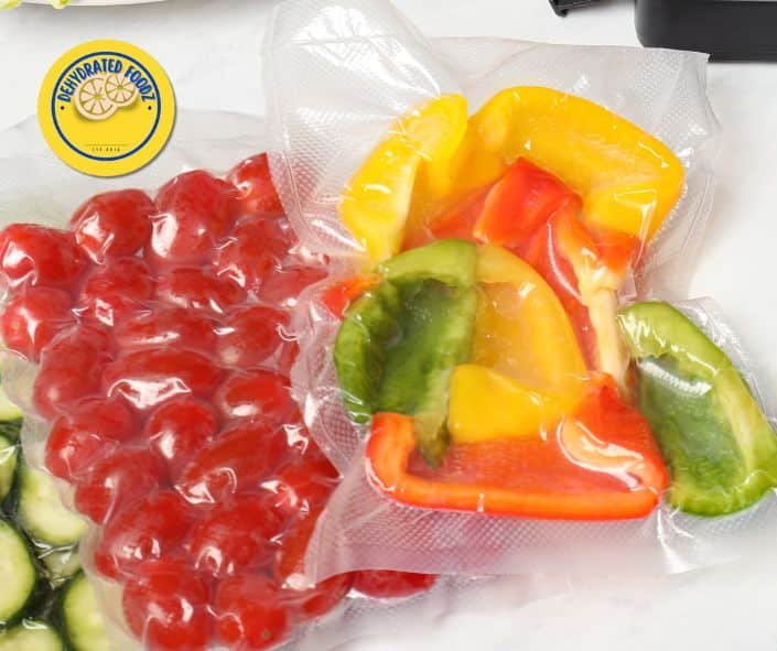 vacuum sealed red tomatoes, green peppers, red and yellow peppers also in a vacuum sealed bag.