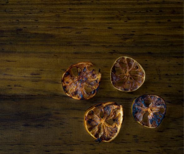 Four slice of lemon wheels dehydrated on a wooden background
