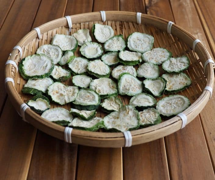 dried zucchini in a basket on a wooden table