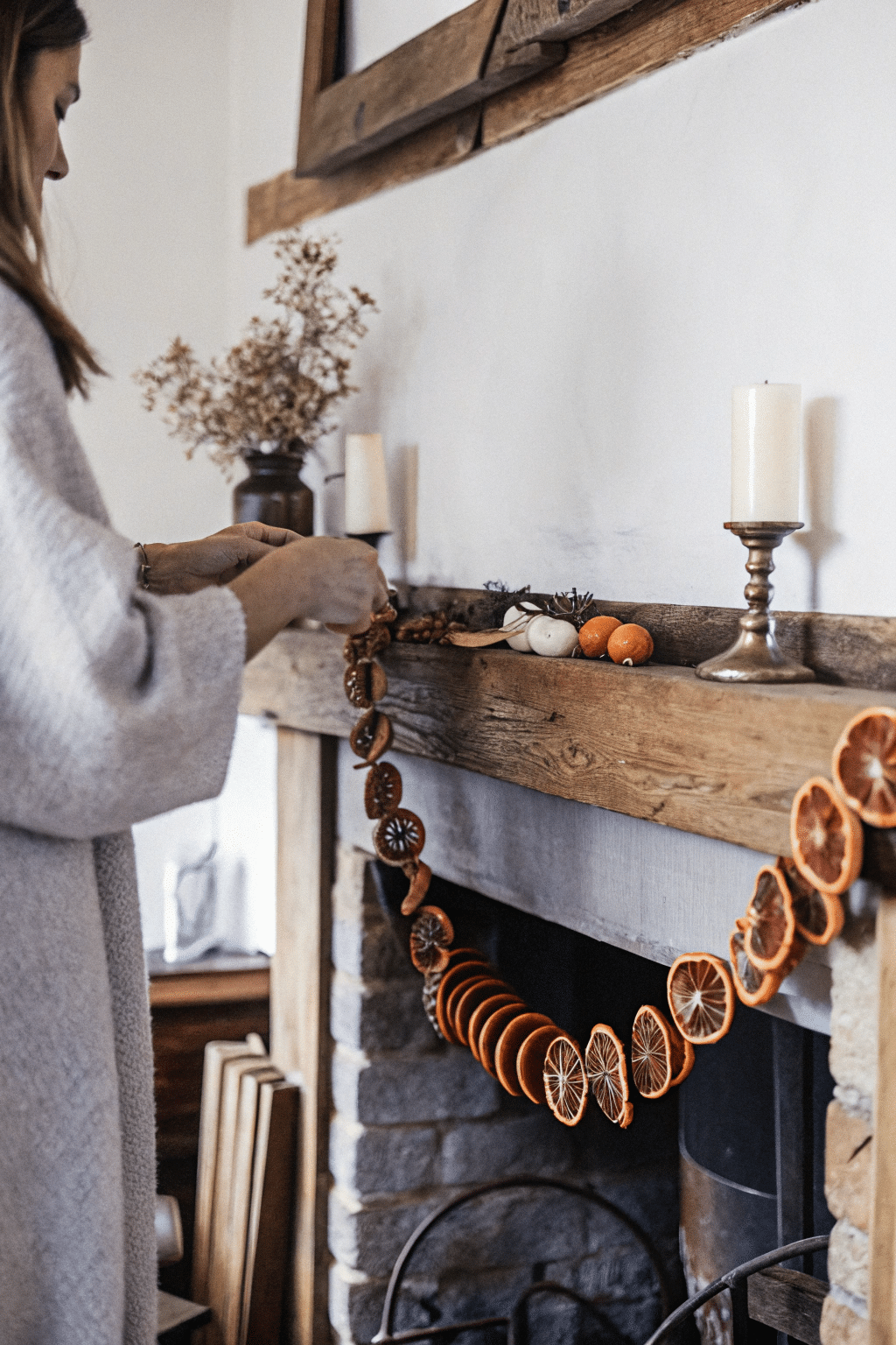 A dried orange garland draped over a rustic wooden mantel, enhancing the farmhouse decor.