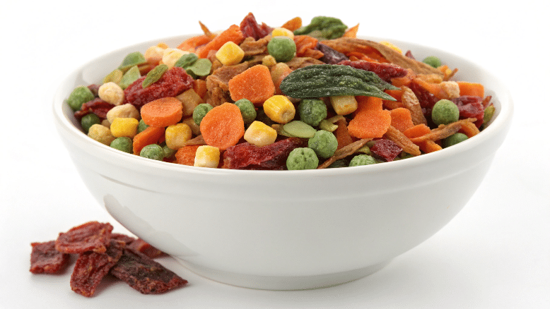 Dried vegetables and herbs in a white bowl.