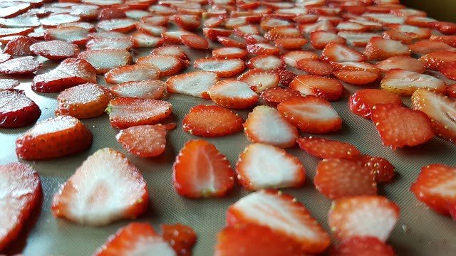 sliced strawberries on a tray getting ready to be dehydrated