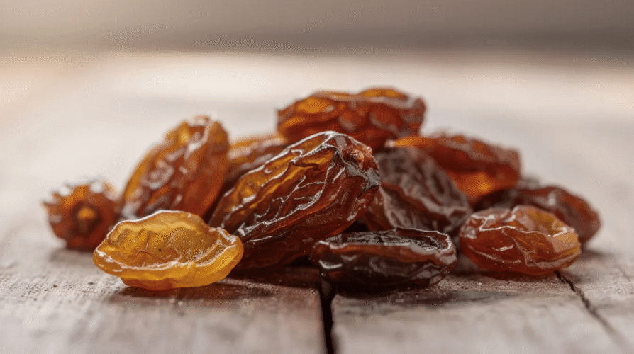 The image features a bowl filled with a variety of raisins, including golden and black raisins, highlighting their rich, sweet appearance. Raisins, which are dried grapes, offer numerous health benefits such as improving digestive health and potentially lowering blood pressure, making them a nutritious addition to a daily diet.