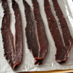 strips of beef jerky on a parchment paper