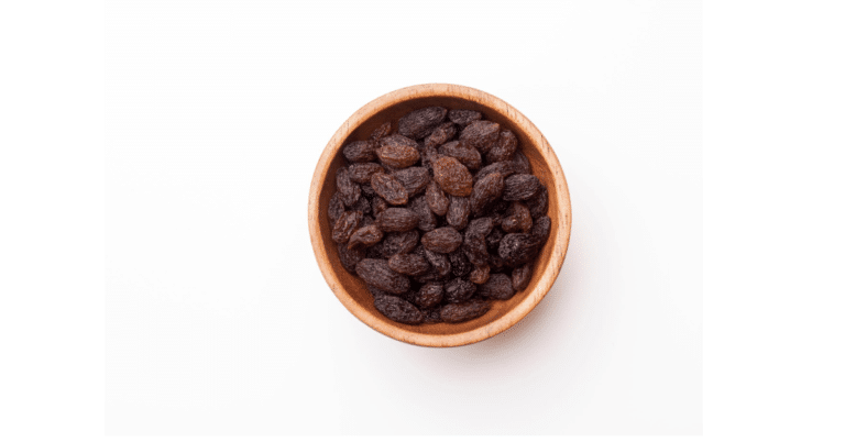 sultanas in a wooden bowl on a white background