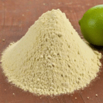 Lime powder next to lime on w ood background