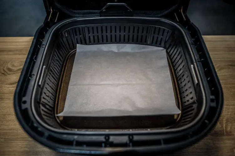 Air fryer with lined parchment paper.