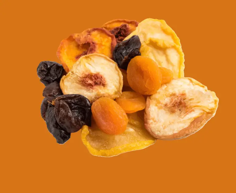 dried apricots, dried mango and other fruit on a an orange background.