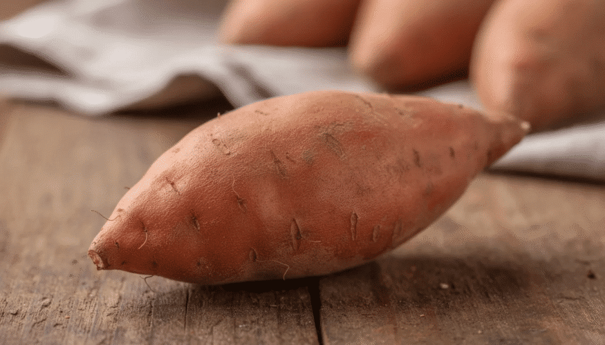 The image features a vibrant orange sweet potato, showcasing its smooth skin and rich color, ideal for recipes like mashed sweet potatoes or dehydrated sweet potatoes. It's a versatile ingredient that can be prepared in various ways, including baking, boiling, or slicing for drying.