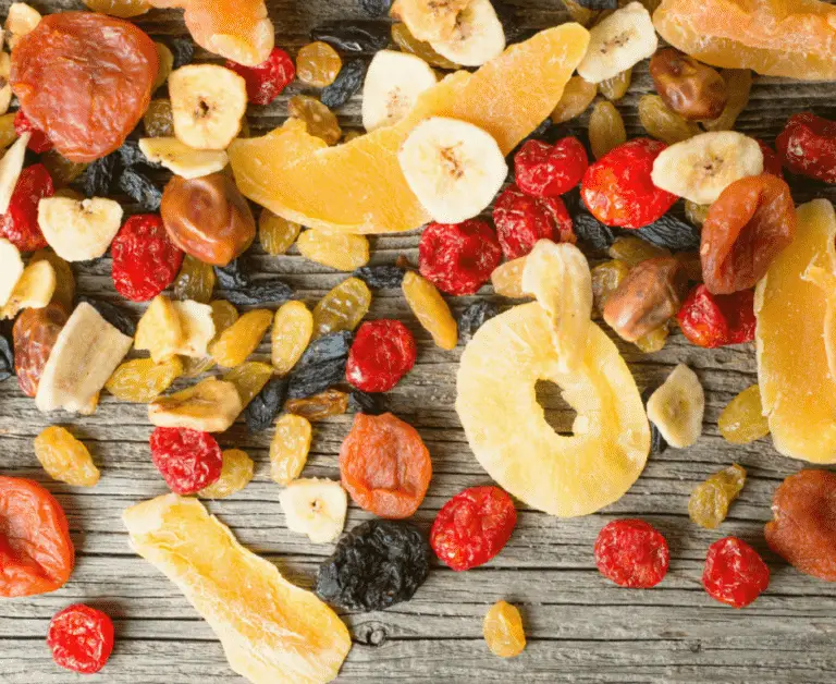dried fruits such as dried banana chips, dried pineapple rings, dried berries on wooden background.