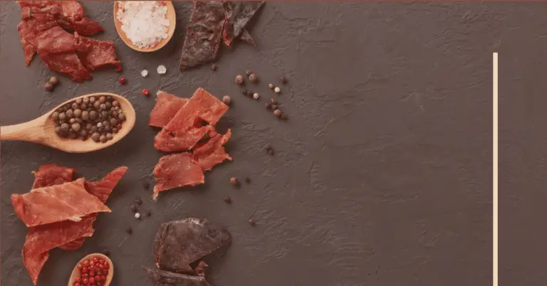 variety of beef jerky on a grey background.