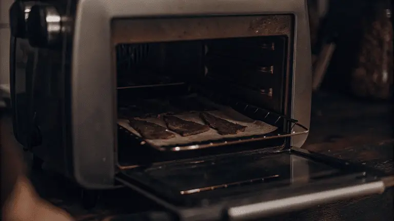 Air fryer oven with jerky slices.