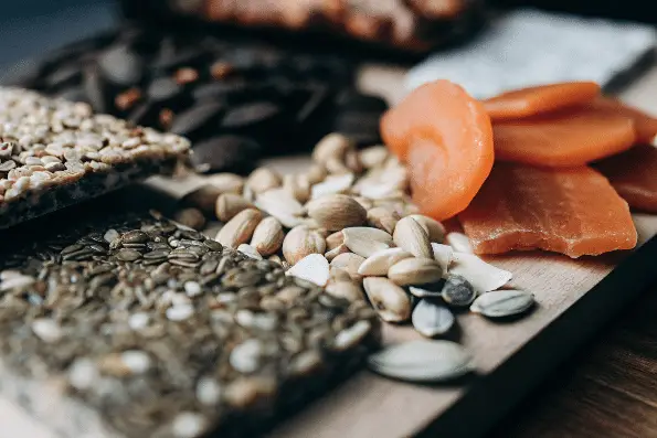 A closeup image of dried papaya next to trail mix.