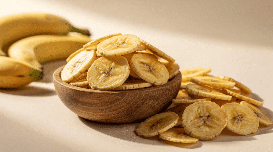 The image features a bowl filled with crispy banana chips, showcasing their golden-brown color and crunchy texture. These dehydrated snacks are perfect for a healthy treat, highlighting the fun and flavorful method of making chips using a food dehydrator.