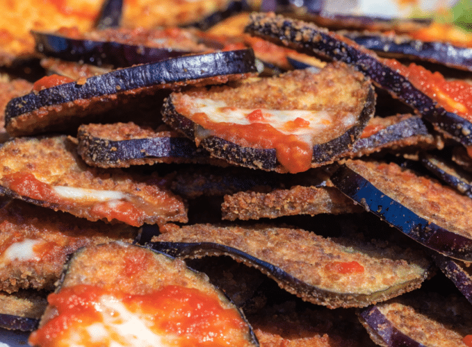 Stacked crispy breaded eggplant slices with tomato sauce and melted mozzarella cheese.