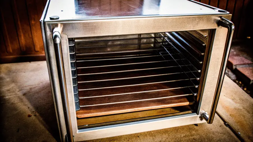 Stainless steel food dehydrator on a kitchen table.