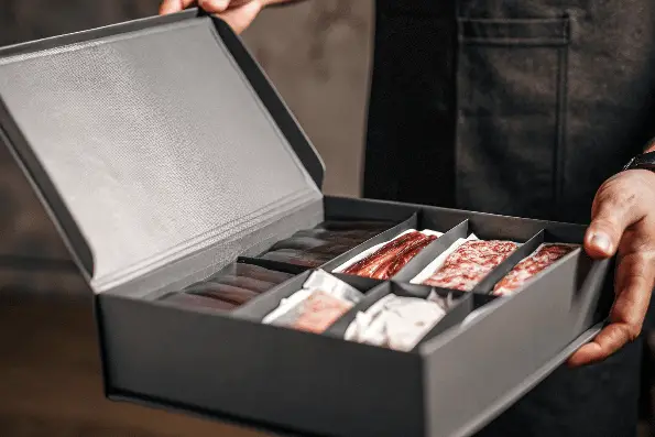 A person holding a meat subscription box.
