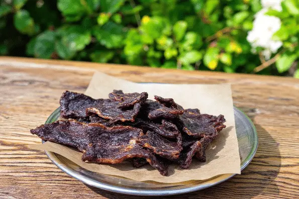 Deer jerky snack on a metal plate,