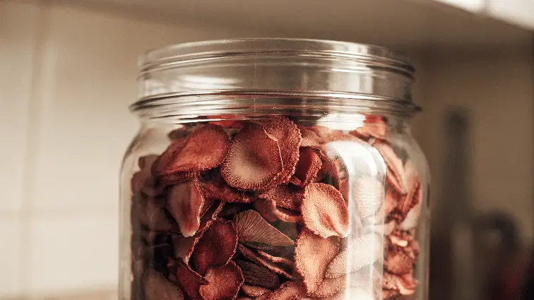Dried strawberry chips in a mason jar.