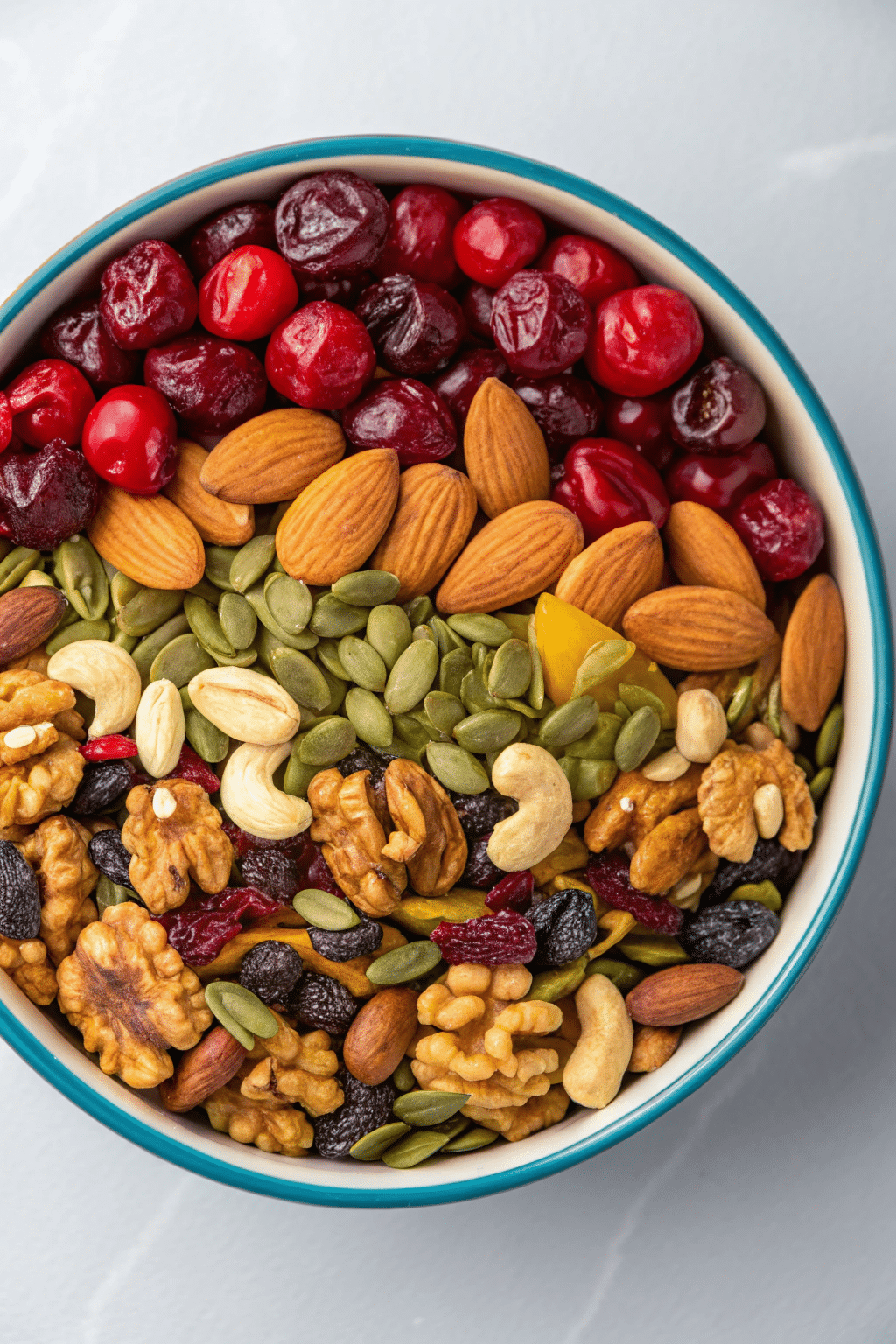 A vibrant mix of dried cherries, nuts, and seeds, arranged in a bowl, ready as a healthy and flavorful snack.