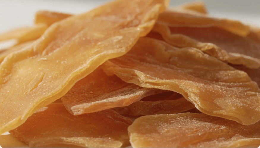 A close-up photograph showcases tender golden slices of soft dried mangoes, highlighting their chewy texture and natural sweetness. These delicious dried fruits are perfect for snacking, offering a flavorful and nutritious option for dessert or a healthy treat.